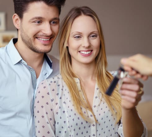 image of a couple receiving a set of keys, they take the key knowing that they are covered by the best Renters' Insurance polcy in Bartlett TN